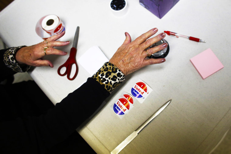 A volunteer poll worker rings a bell to count votes at a polling station on November 6, 2012 in Richmond, Wisconsin.