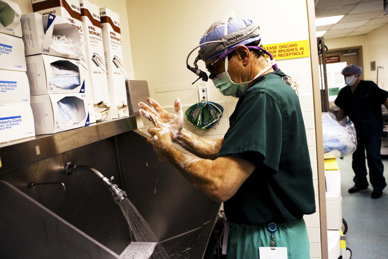 A doctor washes his hands just moments before his heart transplant surgery is set to begin at a hospital in the Bronx, New York City.