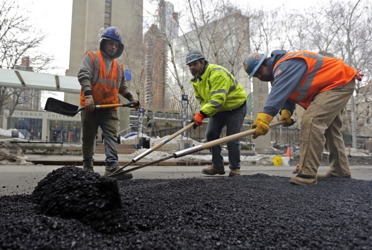 Work crews repair potholes on Columbus Avenue in New York City, New York, February 20, 2014.
