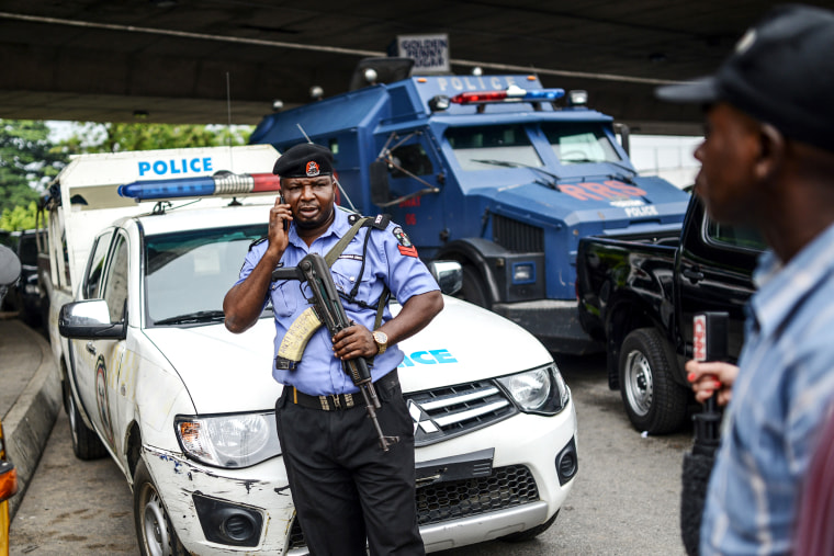 Nigerian security forces stand guard as demonstrators march during a rally to demand the government rescue schoolgirls abducted by suspected Boko Haram militants two weeks ago, in Lagos, Nigeria, May 01, 2014.