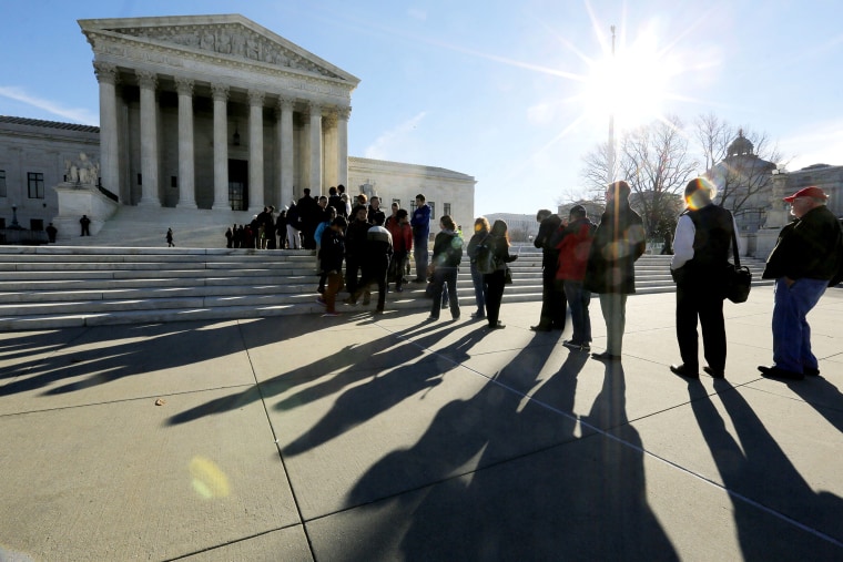 Members of the public cast shadows as they line up in front of the U.S. Supreme Court in Washington