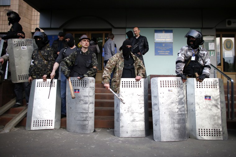 Pro-Russia protesters stand guard at the entrance of the district council building in Donetsk