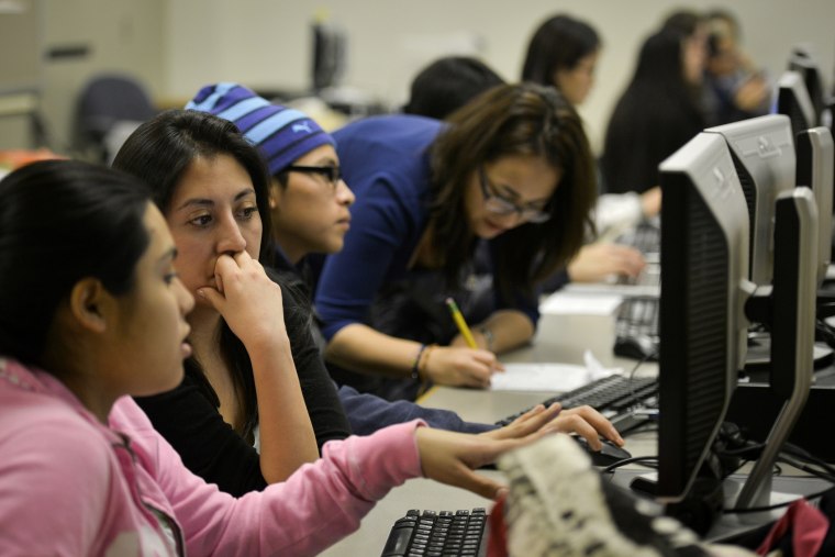 Daniela Martinez, 2nd from L, reads the college essay of undocumented high school student Seila, the only name she wishes to use, at Washington Lee High School on Jan. 23, 2014, in Arlington, VA.