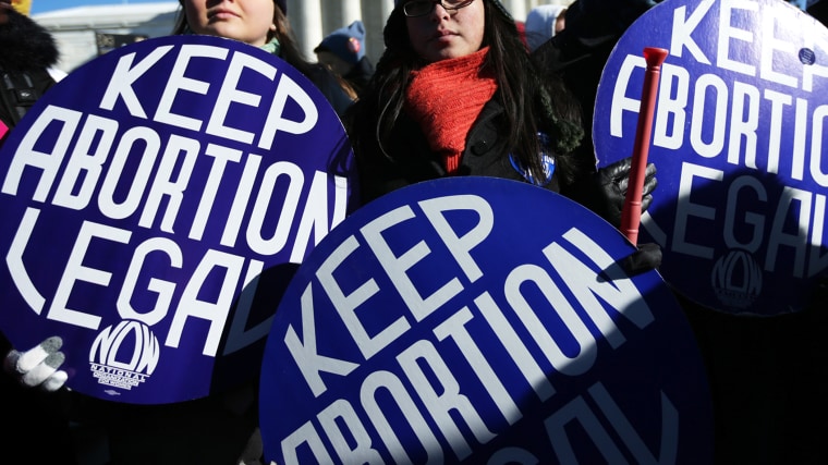 Pro-choice activists hold signs as marchers of the annual March for Life arrive in front of the U.S. Supreme Court January 22, 2014 on Capitol Hill in Washington, DC.
