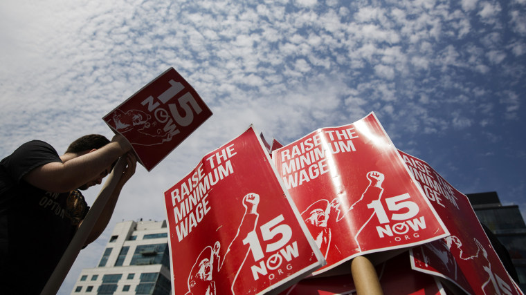 Demonstrators prepare signs supporting the raising of the federal minimum wage during May Day demonstrations in New York
