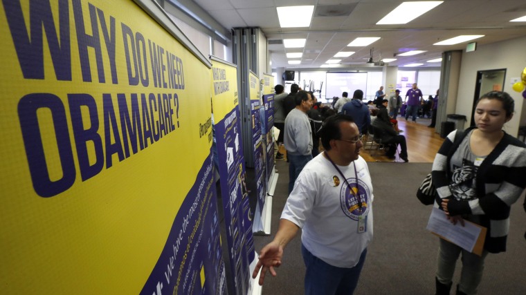 Julian Gomez explains Obamacare to people at a health insurance enrolment event in Commerce, Calif.