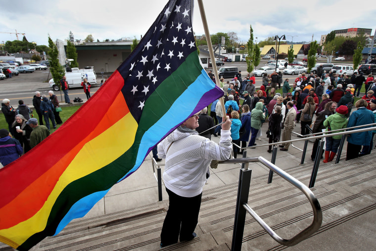 Teresa Shelley waves a rainbow-colored American flag on the steps of The Wayne L. Morse United States Courthouse on April 22, 2014 in Eugene, Ore.