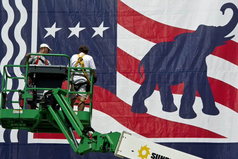Workers mount a giant banner at the Tampa Bay Times Forum ahead of the Republican National Convention in Tampa, Florida, on Aug. 24, 2012.
