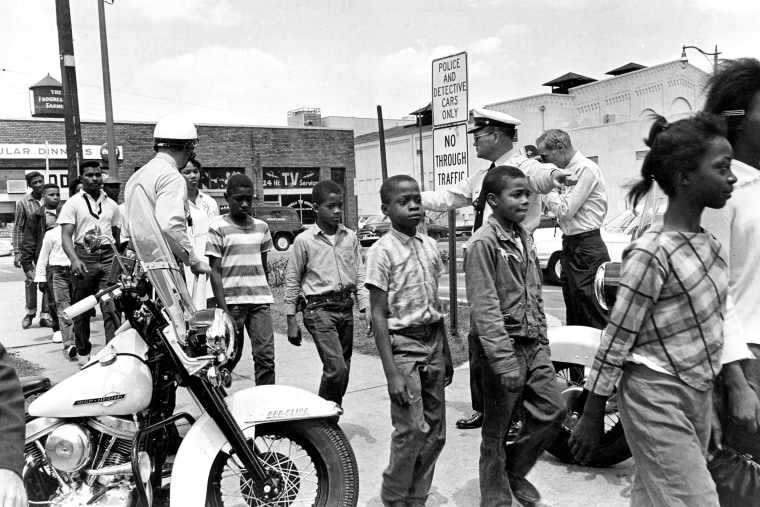 Policemen are lead a group of black school children into jail, following their arrest for protesting against racial discrimination near the city hall of  Birmingham, Ala., on May 4, 1963.