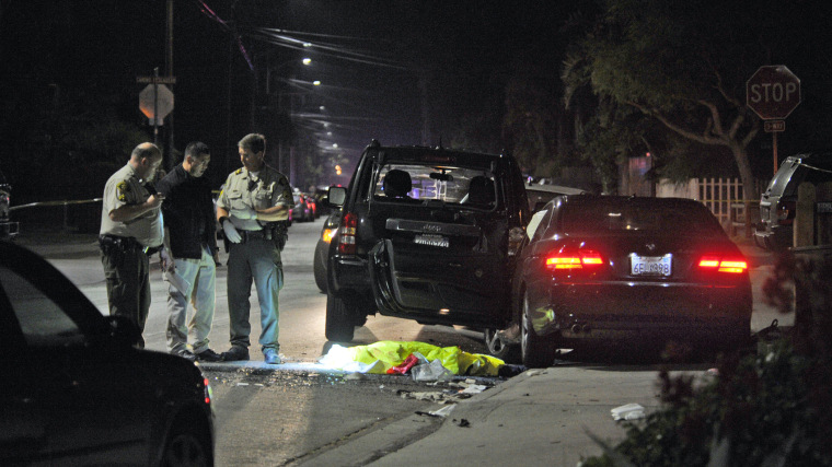 This image provided by the Santa Barbara Independent shows a body covered on the ground after a mass shooting near the campus of the University of Santa Barbara in Isla Vista, Calif., Friday, May 23, 2014.