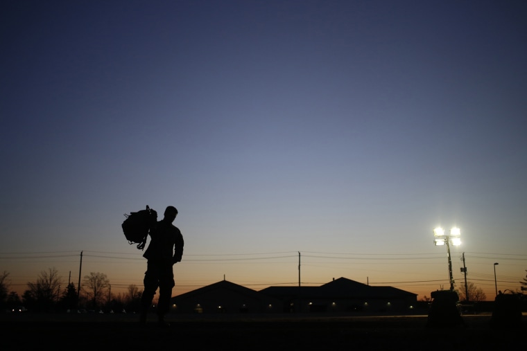 A soldier grabs his rucksack following a homecoming ceremony, Feb. 27, 2014, in Fort Knox, Ky.