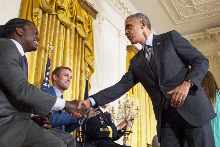 US President Barack Obama shakes hands with panelist and former NFL linebacker LaVar Arrington (L) during the White House Healthy Kids & Safe Sports Concussions Summit, May 29, 2014.