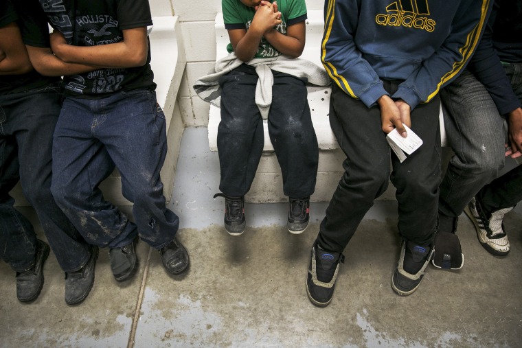 A Honduran child, unsure of his age, sits with other youths waiting to be processed at a U.S. Border Patrol station in Brownsville, Texas, March 25, 2014.