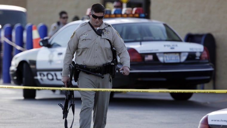 A Las Vegas police officer walks away from the scene of a shooting near a Wal-Mart, Sunday, June 8, 2014, in Las Vegas.