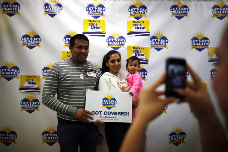 Enrique Gonzalez, 22, (L-R), Janet Regalado, 21, and their nine-month-old daughter Kayleen Gonzalez pose for a photo after signing up for health insurance at an enrolment event in Commerce, California March 31, 2014.