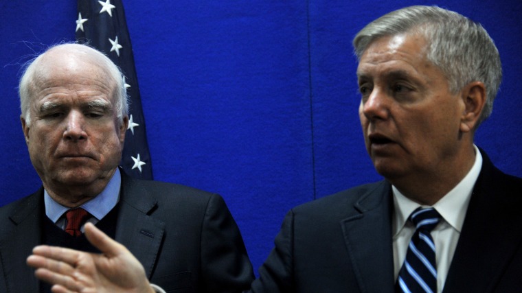 US Senator Lindsey Graham (R) speaks as Senator John McCain (L) looks on during a press conference at the US Embassy in Kabul on January 2, 2014.