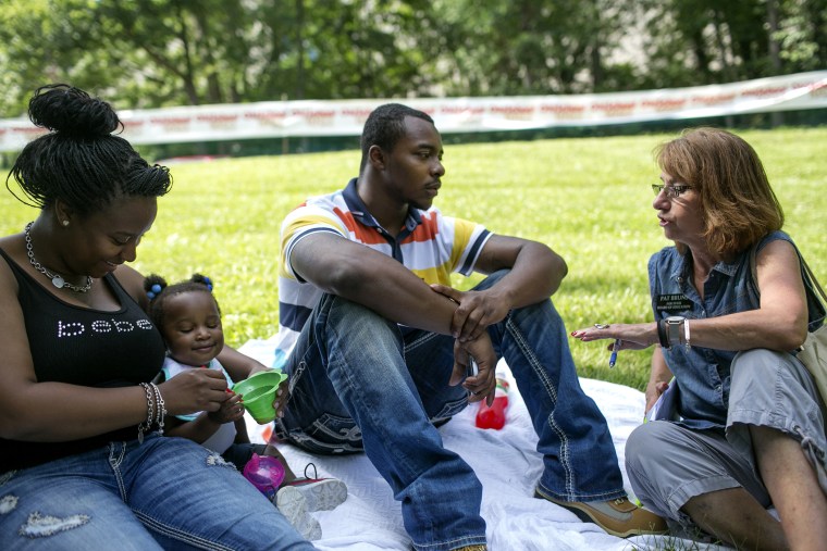 Pat Bruns, right, explains the petition to Tonnisha Penn, left, Ahnyluh White, 1, center, and Cortez Holloway at Radio One Old School 100.3's Jammin in the Park in Cincinnati on June 21, 2014.