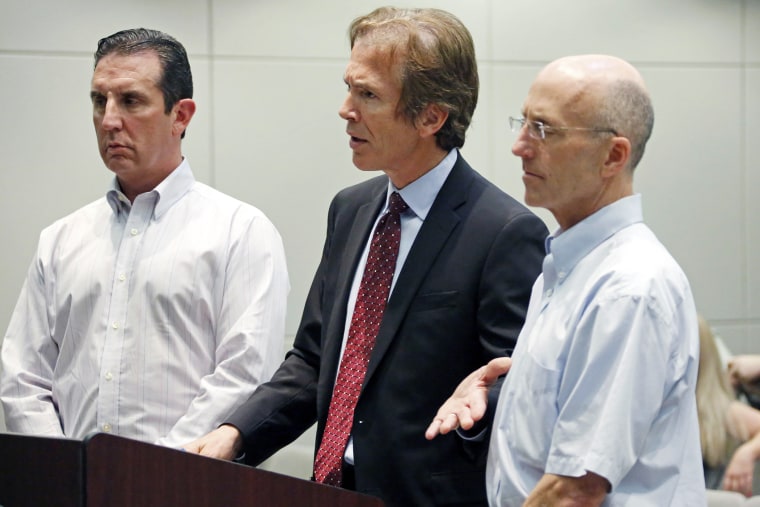 Mark Mayfield, a member of the board of the Central Mississippi Tea Party, right, listens as his attorney Merrida Coxwell, center, responds to questions, May 22, 2014, during an initial court appearance.