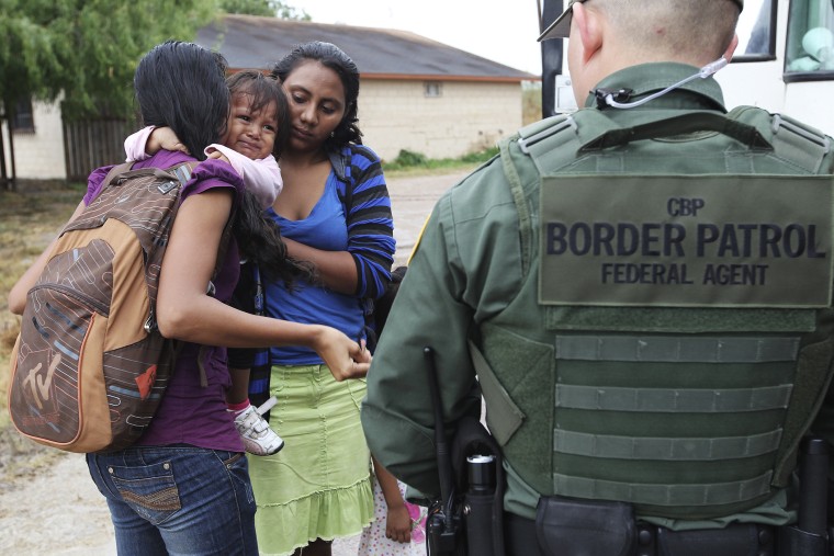 An infant cries as U.S. Border Patrol agents process a group of immigrants in Granjeno, Texas, outside of McCallen on June 25, 2014.