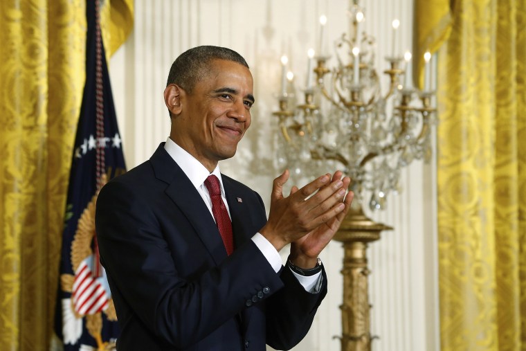 U.S. President Barack Obama applauds new U.S. citizens after they took the Oath of Allegiance at a naturalization ceremony for active duty service members and civilians at the White House in Washington July 4, 2014.