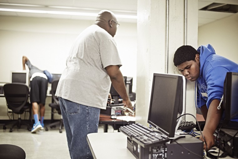 Willie Scott helps his teacher move old computers at Oakland High School in Oakland, California, on July 7, 2014.