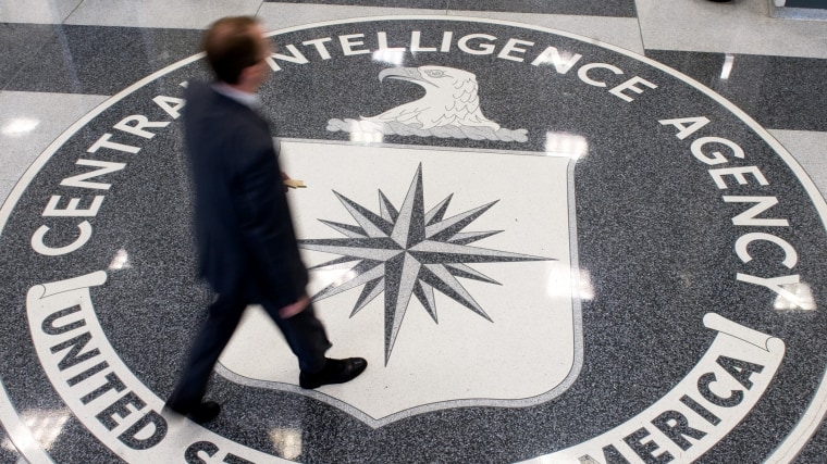 A man crosses the Central Intelligence Agency (CIA) logo in the lobby of CIA Headquarters in Langley, Virginia.