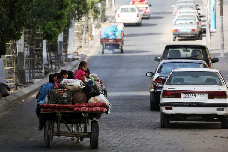 Palestinians flee their homes and head towards a United Nations' school to seek shelter in Gaza City, July 13, 2014.