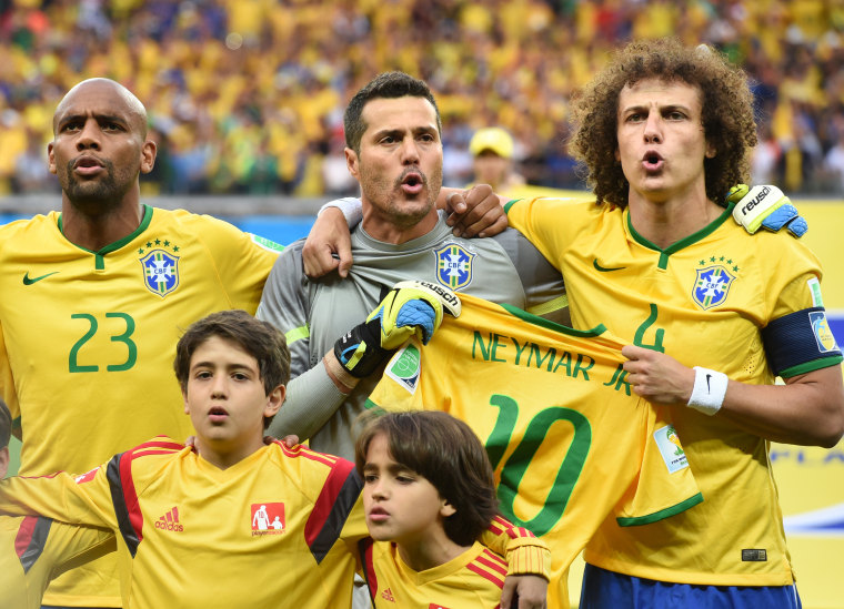 Brazil's David Luiz (R) and goal keeper Julio Cesar hold the jersey of their injured team mate Neymar during the national anthem prior to the FIFA World Cup 2014 semi-final soccer match between Brazil and Germany at Estadio Mineirao in Belo Horizonte, Brazil, July 8, 2014.