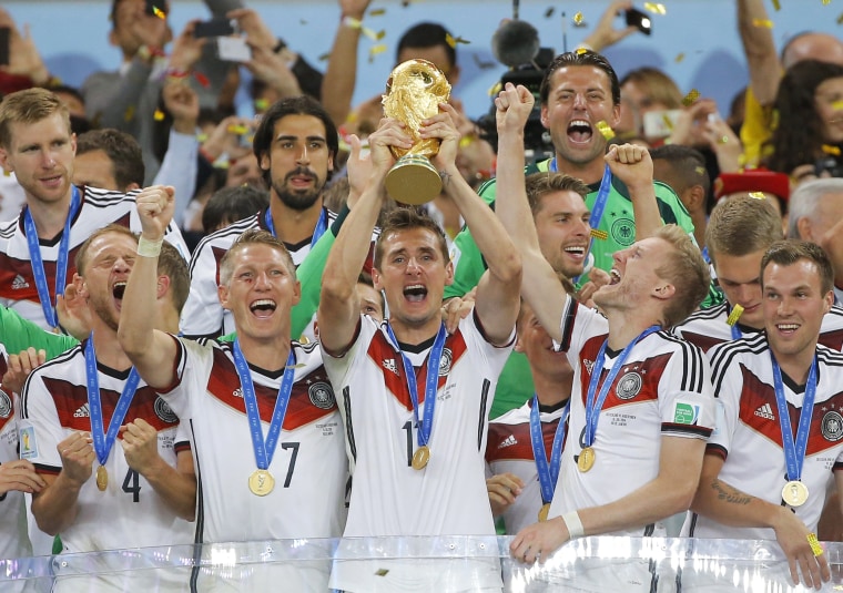 Miroslav Klose (C in front row) and other Germany players celebrate with the World Cup trophy after beating Argentina 1-0 to win their fourth World Cup title at the Maracana Stadium in Rio de Janeiro, Brazil, on July 13, 2014.