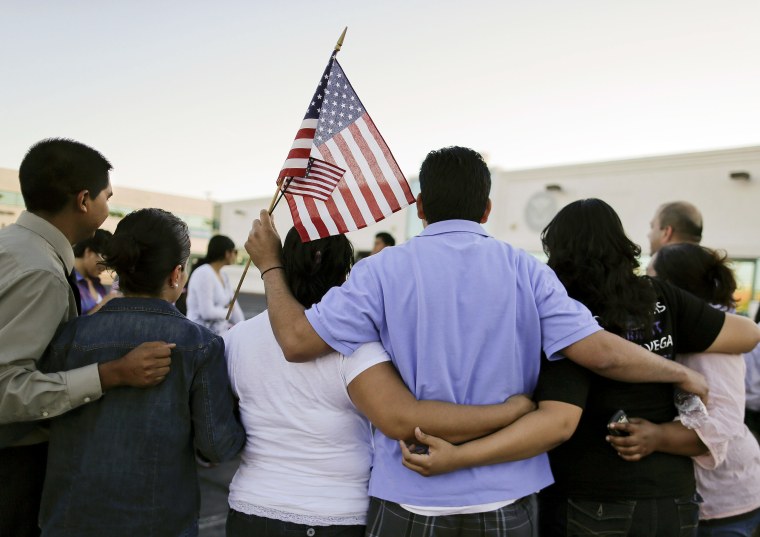 People gather for a photo outside the Immigration and Customs Enforcement offices during an immigration vigil, on April 10, 2013, in Las Vegas.