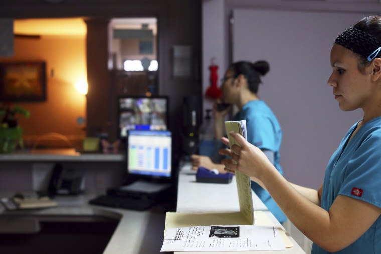 Medical assistant Nyla Munoz closes a walk-in patient's file at the Whole Women's Health Clinic in McAllen.