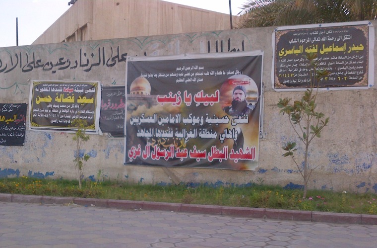 Posters of Shia militia \"martyrs\" who died fighting in Syria and Iraq paper the walls of the Shia neighborhood of Hurriyya, in Baghdad, on July 5, 2014.