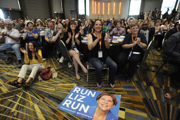 A \"Run Liz Run\" poster sits on the floor in front of LaNae Havens, center, as she cheers for Sen. Elizabeth Warren, D-Mass., at the Netroots Nation conference in Detroit, Mich., July 18, 2014.