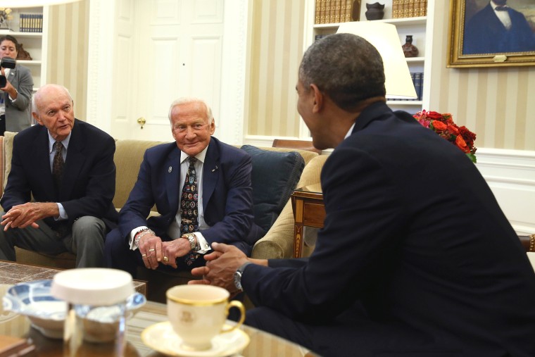 U.S. President Barack Obama (R) meets astronauts Michael Collins (L) and Buzz Aldrin (C) during a visit in the Oval Office at the White House, July 22, 2014 in Washington, DC.
