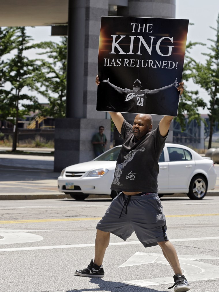 Graphic designer Alvin Smith (not my uncle) holds up a poster in the street outside Quicken Loans Arena in Cleveland on July 11. (AP Photo/Mark Duncan)