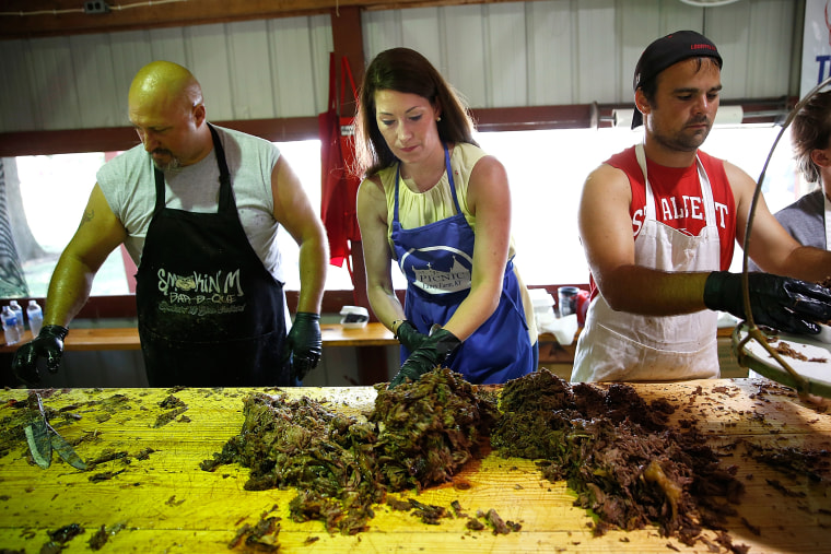 Kentucky's Democratic U.S. Senate nominee, and Kentucky Secretary of State, Alison Lundergan Grimes (2nd L) chops mutton barbeque at the Elder Family's barbeque stand at the Fancy Farm picnic Aug. 2, 2014 in Mayfield, Ky.