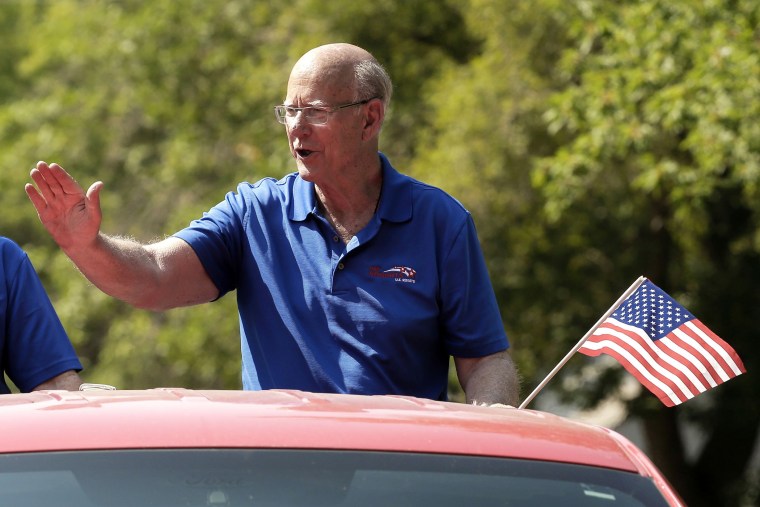 U.S. Sen. Pat Roberts waves to the crowd as he rides on the back of a pickup in a parade Saturday, Aug. 2, 2014, in Gardner, Kan.