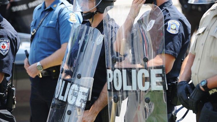 Police officers equipped in riot gear line up during a protest of the shooting death of 18-year-old Michael Brown outside Ferguson Police Department Headquarters August 11, 2014 in Ferguson, Missouri.