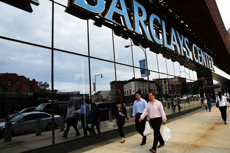 People walk near the Barclays Center on August 12, 2014 in the Brooklyn borough of New York City.