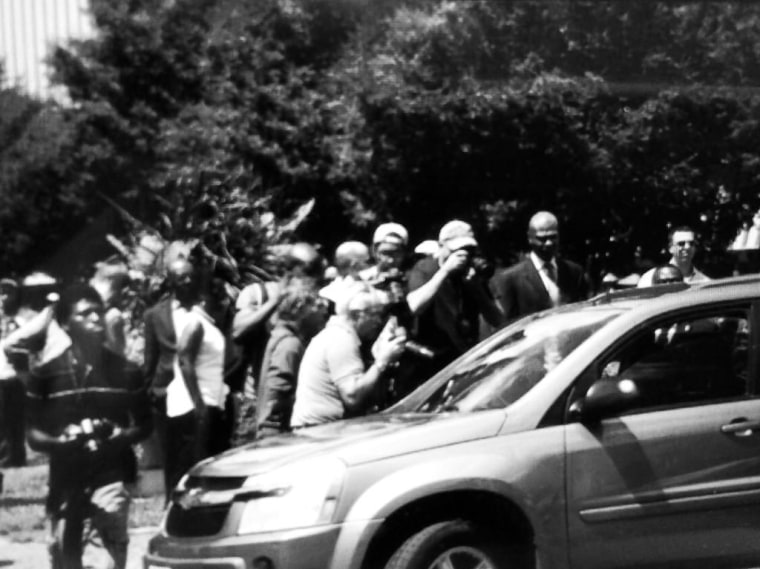 Media swarming around the car of Michael Brown's mother as she leaves Tuesday's press conference with Rev. Al Sharpton.