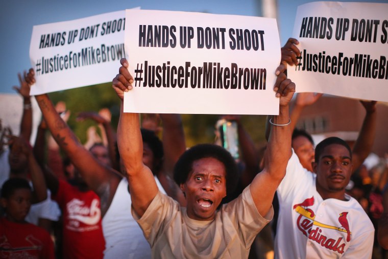 Demonstrators protest the killing of teenager Michael Brown outside Greater St. Marks Family Church while Brown's family, along with civil rights leader Rev. Al Sharpton and a capacity crowd of guests, met inside to discuss the killing on August 12, 2014