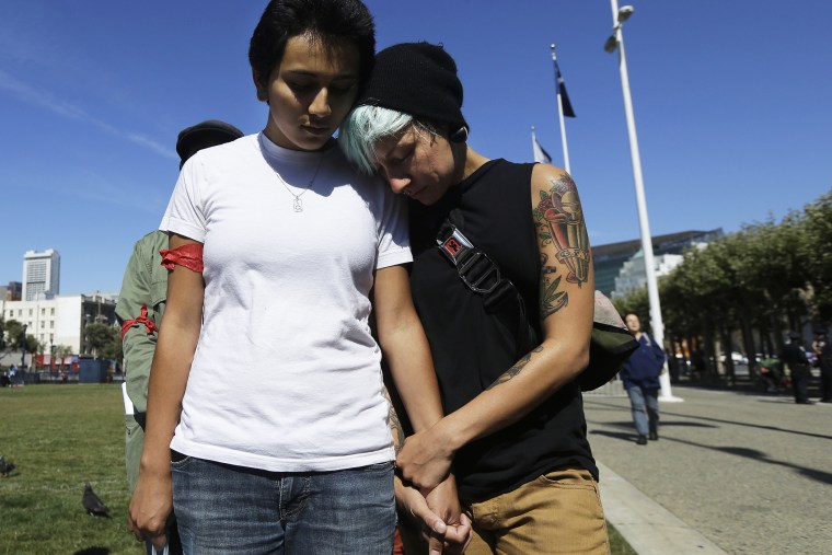 Gabriela Serrano, 21, left, and A.J. James, 27, listen to a prayer during a vigil for Michael Brown of Ferguson, Mo., in San Francisco, Thursday, Aug. 14, 2014.