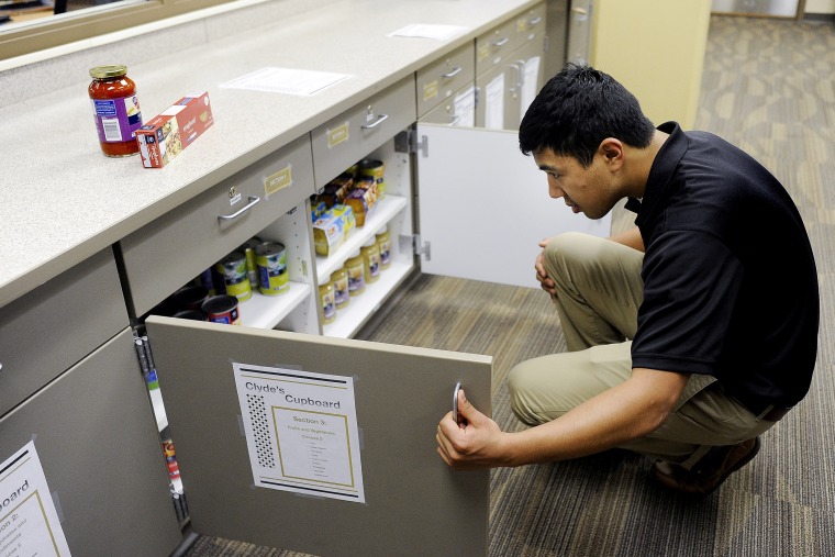 University of Colorado-Colorado Springs junior Chingis Zhanturiyev looks through a cabinet full of food on March 20, 2014, at Clyde's Cupboard, a campus food pantry to help serve students in need.