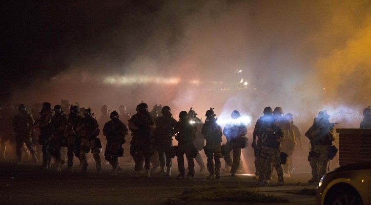 Image: Riot police clear demonstrators from a street in Ferguson