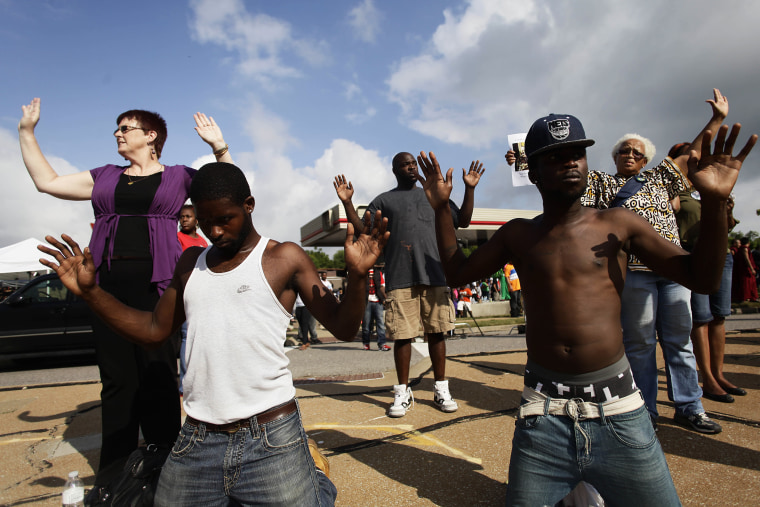 Demonstrators protest Michael Brown's murder with their hands in the air August 17, 2014 in Ferguson, Missouri.