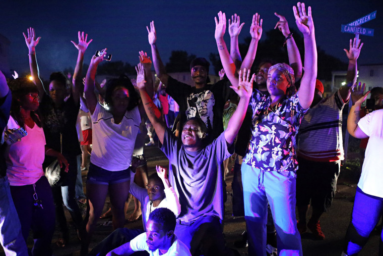 ''Don't shoot us'' cries out the crowd as they confront police officers arriving to break up a crowd in Ferguson, Mo., Aug. 9, 2014.