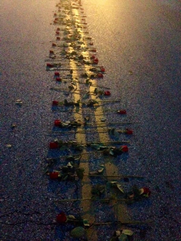 Roses line the street where Mike Brown was shot and killed, Aug. 21, 2014.