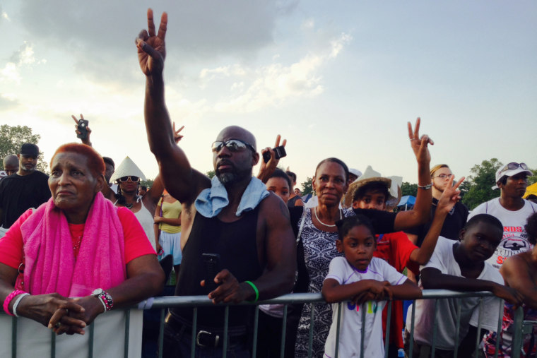 People in the crowd gesture at the Peace Festival honoring Michael Brown, in St. Louis, Mo., on Aug. 24, 2014.