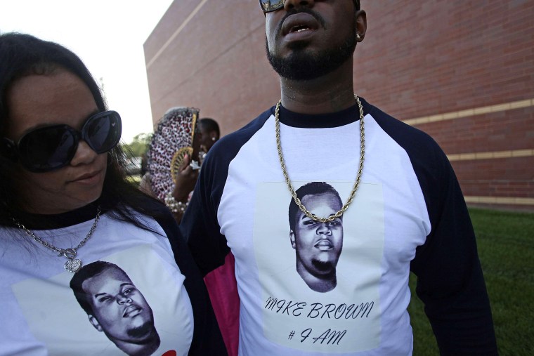 People wearing T-shirts with pictures of Michael Brown wait in line to attend his funeral at Friendly Temple Missionary Baptist Church in St. Louis, Missouri