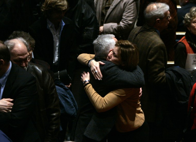 Mourners hug as others leave following a memorial service for Kenneth Yost at First Presbyterian Church Monday, Feb. 11, 2008, in Kirkwood, Mo.